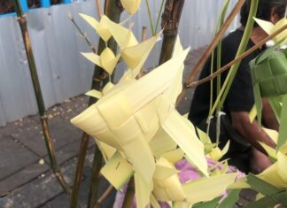 Disabled homeless man fights for a living by selling craft art made of palm leaves on streets in Pattaya