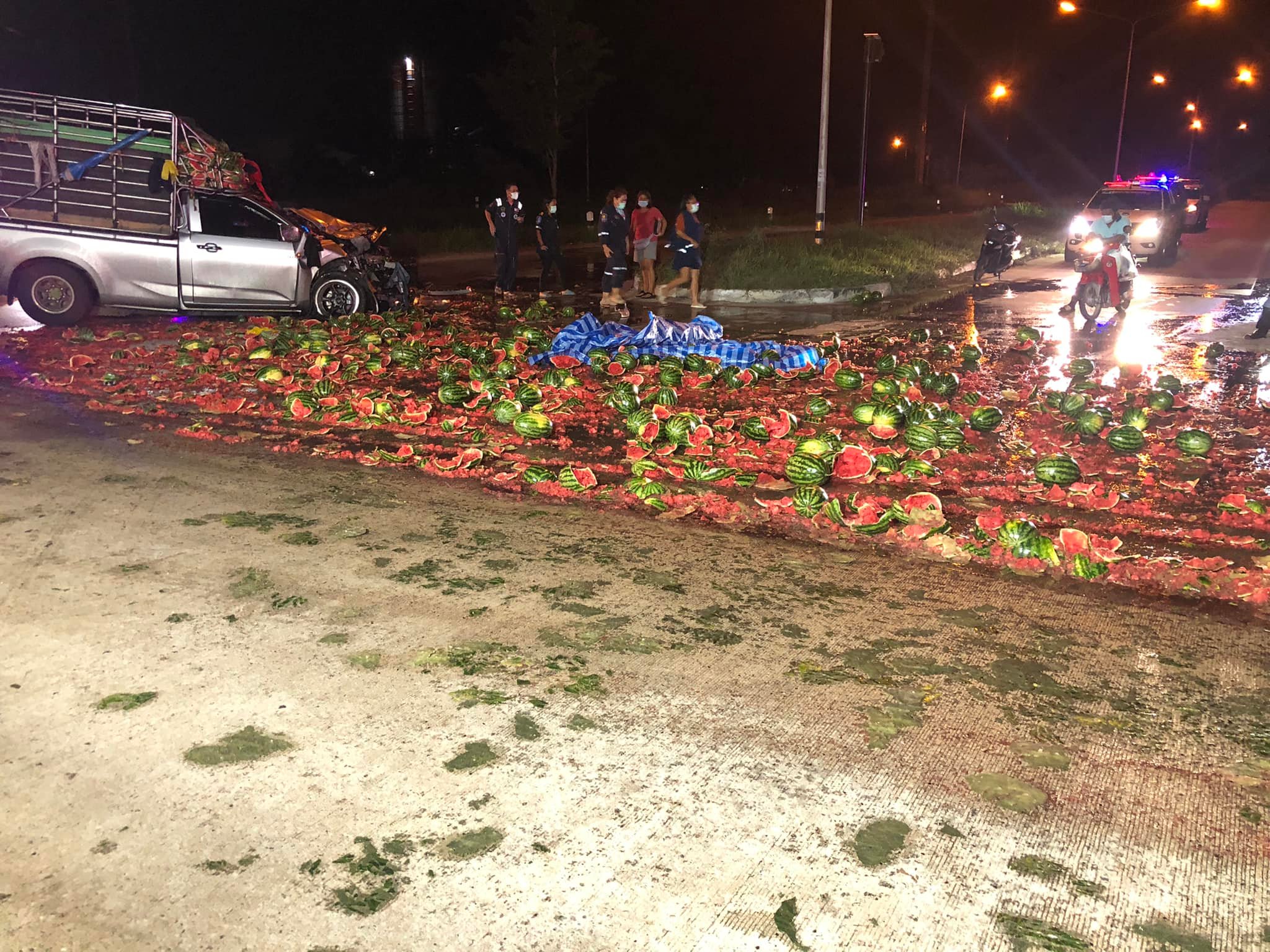 Hundreds of watermelons scattered across road after pickup truck driver overturns in Ban Bueng