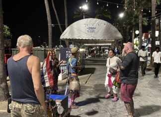 Un musicien ambulant captive les touristes avec une performance animée sur la plage de Pattaya