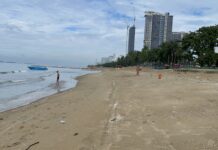 Utländskt par kör motorcykel på sandstranden i Jomtien, väcker upprördhet