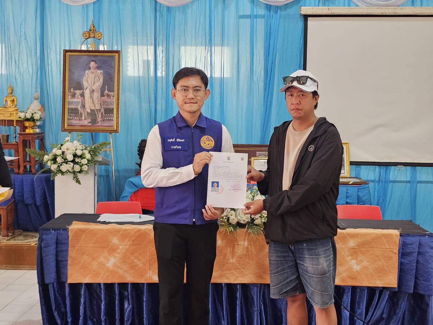 Officials presenting registration documents to Koh Larn accommodation operators at Wat Mai Samran