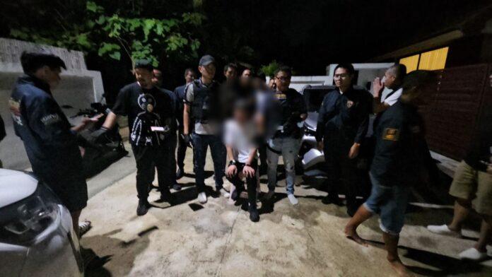 Pattaya news photograph of Thai police officers at night on a residential driveway in Banglamung district, Pattaya Thailand, during the operation that uncovered a military-grade weapons cache